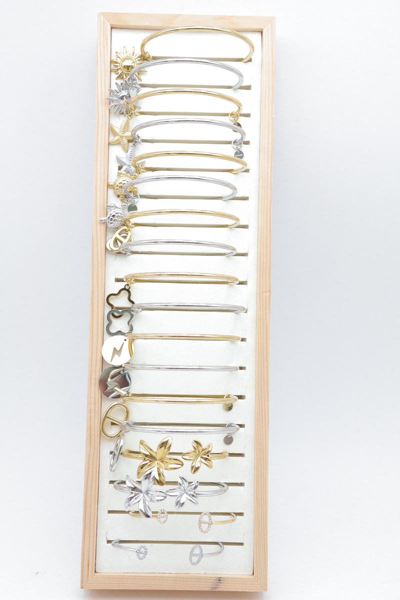 Set of 18 charm bangles on wooden tray