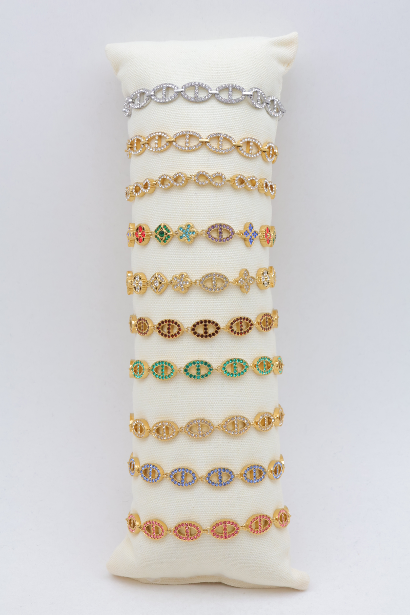 Lot de 10 bracelets en acier inoxydable à strass et motifs maille marine, infini et trèfle sur présentoir coussin en tissu — Multicolore