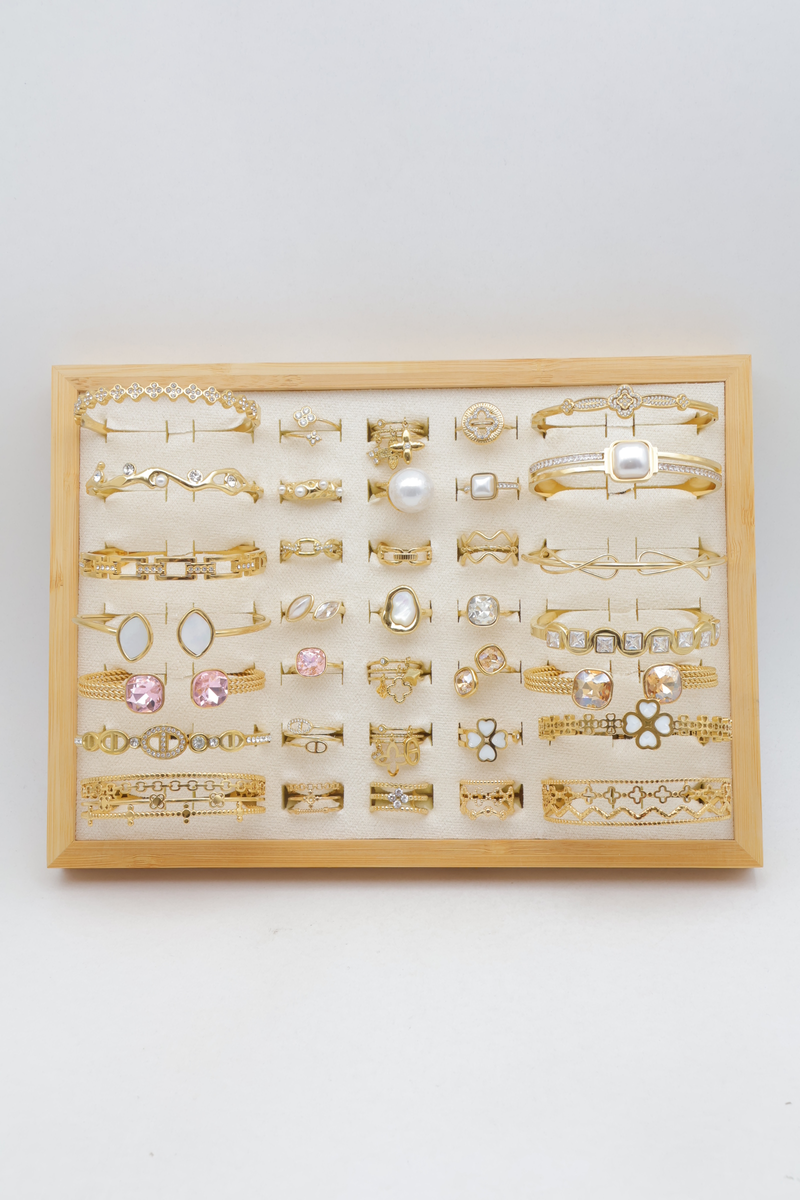 Assortment of 21 rings and 14 bangles with rhinestones, pearls and clovers